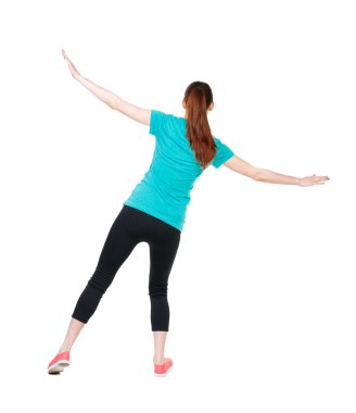 Arkadan görünüş kadın kollarını sallayarak dengeler.