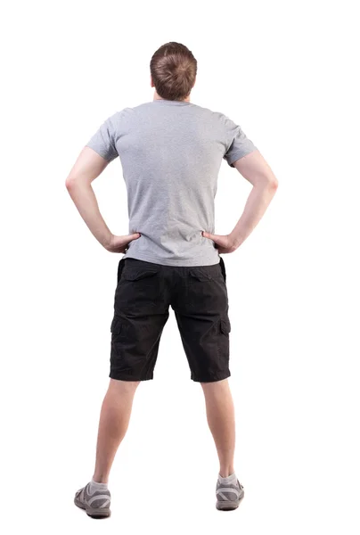 ハンサムな男の t シャツとショート パンツ探しているの背面図 — ストック写真