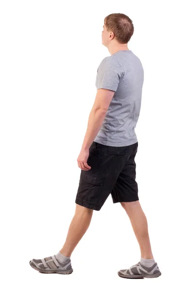 Back view of walking handsome man in shorts and sneakers — Stock Photo, Image