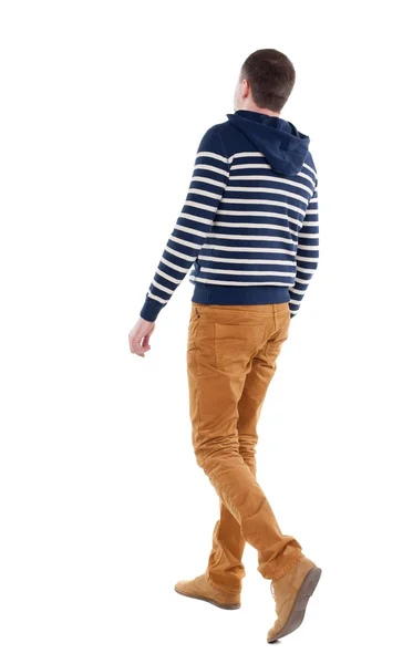 Back view of walking handsome man in jeans and striped sweater. — Stock Photo, Image