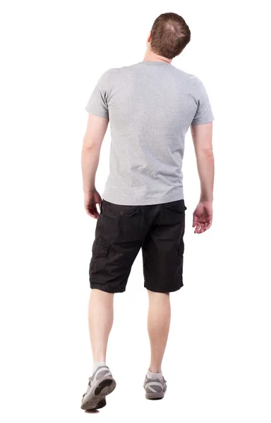 Back view of walking handsome man in shorts and sneakers — Stock Photo, Image