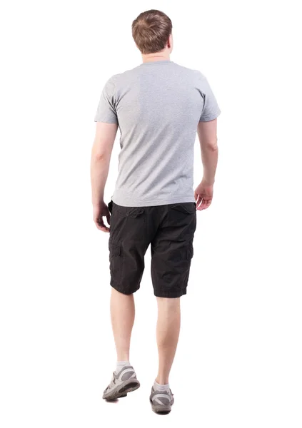 Back view of walking handsome man in shorts and sneakers — Stock Photo, Image