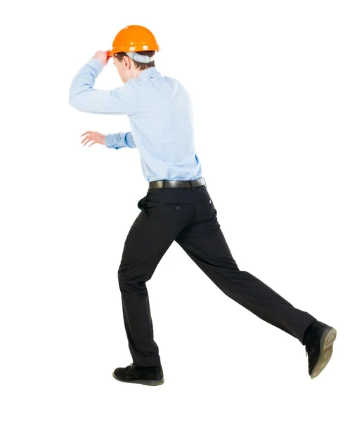 Rückansicht des laufenden Ingenieur im Helm. zu Fuß Kerl in Bewegung. — Stockfoto
