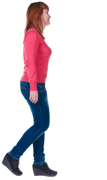 Back view of walking cheerful redhead girl in red sweater — Stock Photo, Image