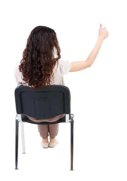 Rückansicht des junge schöne Frau sitzen auf Stuhl und Daumen — Stockfoto