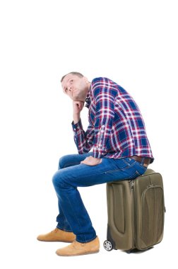 Bavul üzerinde oturan bir adam arkadan görünüm.