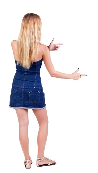 Back of view beautiful young  woman in jeans dress pointing at w — Stock Photo, Image