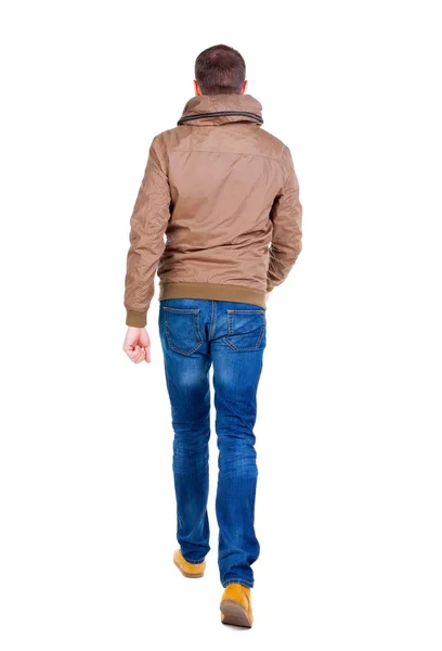 Hintere Ansicht gehen gut aussehender Mann in Jeans und Jacke. — Stockfoto