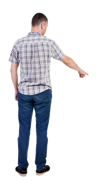 Achteraanzicht van jonge mannen in shirt en spijkerbroek te wijzen. jonge kerel gebaar. Achteraanzicht mensen collectie. achterzijde zicht op persoon. geïsoleerd op witte achtergrond. — Stockfoto