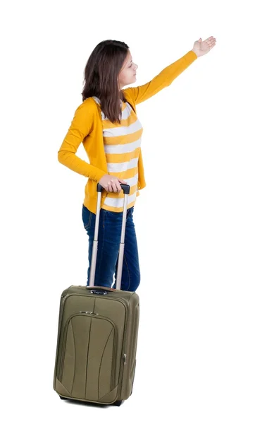 Back view of walking  woman  in cardigan with suitcase pointing. — Stock Photo, Image