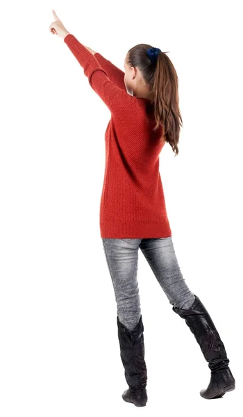 Back view of young brunette woman pointing at wall . — Stock Photo, Image