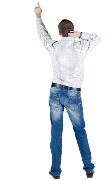 Young man pointing at wall. rear view. — Stock Photo, Image