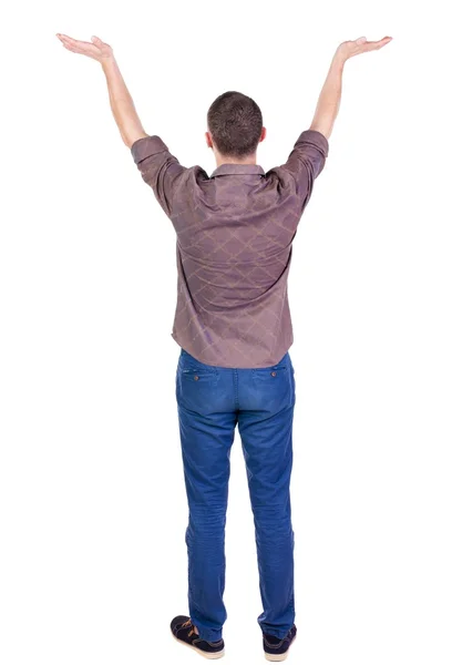 Back view of Beautiful man in jeans looking at wall and Holds  h — стоковое фото