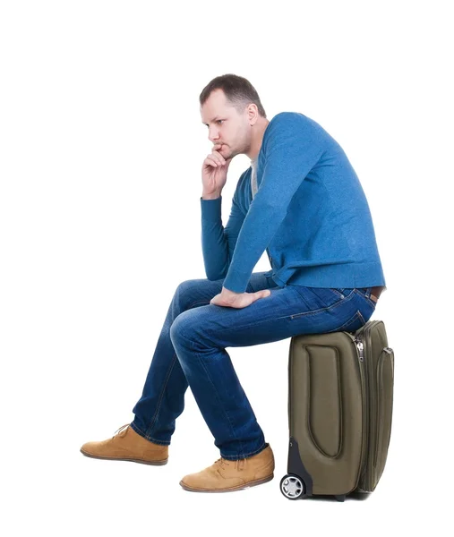 Back view of a man sitting on  suitcase. — Stock Photo, Image