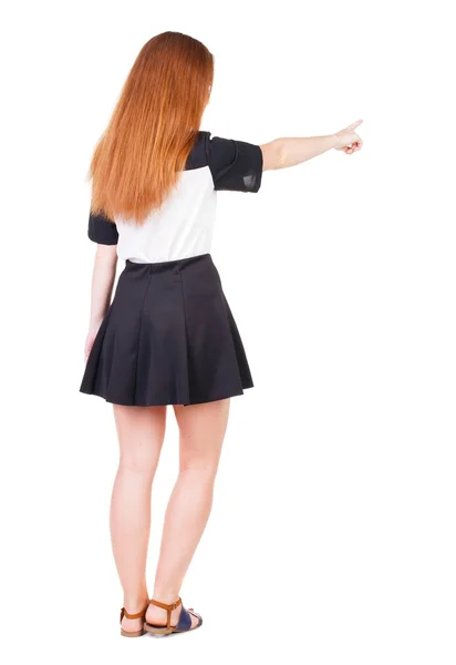 Vista posterior de mujer pelirroja joven apuntando a la pared. hermosa gir — Foto de Stock