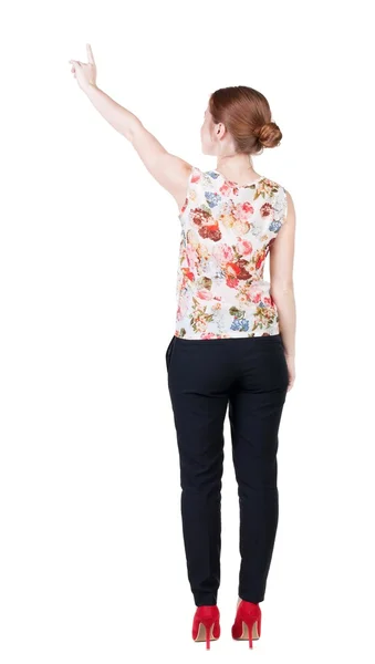 Back view of young redhead business woman pointing at wal — Stock Photo, Image
