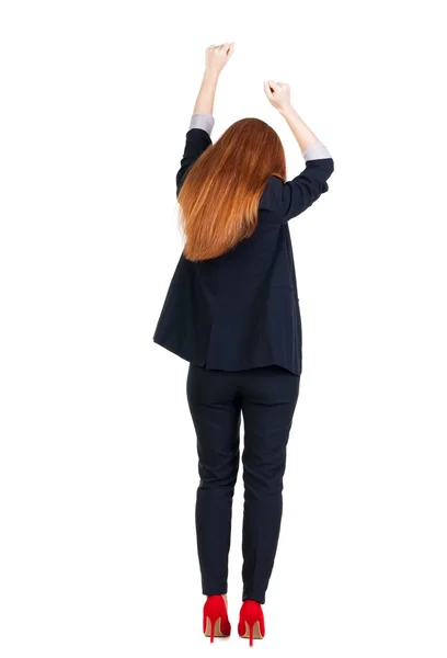 Back view of Beautiful business woman in suite looking at wall and Holds hand up. — Stock Photo, Image