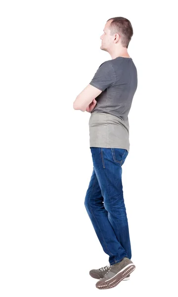 Vista posterior de joven con camiseta y pantalones vaqueros mirando. — Foto de Stock