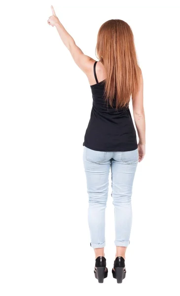 Vista posterior de la mujer señala. hermosa pelirroja en jeans. —  Fotos de Stock