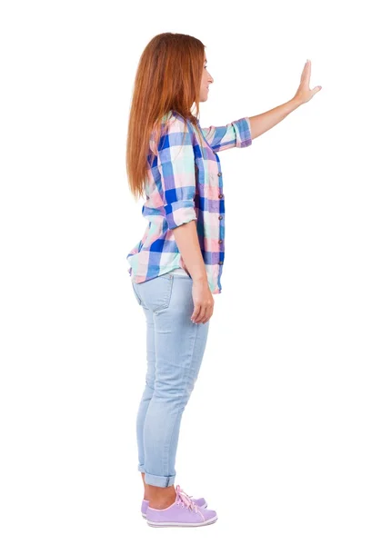 Mujer joven en pantalones vaqueros presiona hacia abajo en algo. —  Fotos de Stock