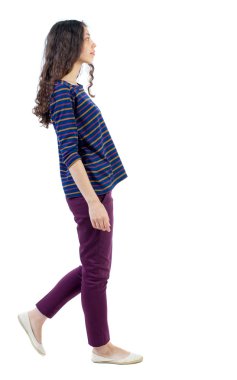 Arkadan görünüşü yürüyen kıvırcık kadın.