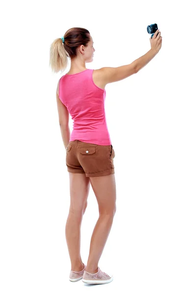 Vista da bela jovem de pé e usando um móvel traseira — Fotografia de Stock