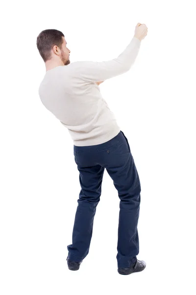 Vista posteriore di un uomo in piedi che tira una corda dall'alto o si aggrappano t — Foto Stock