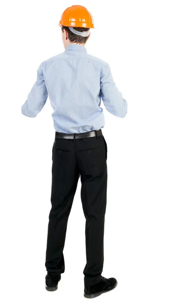 Backview of an engineer in construction helmet stands. — Stock Photo, Image