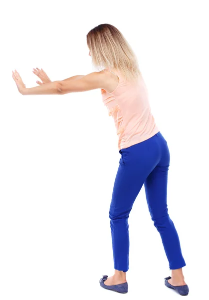 Back view of woman pushes wall. — Stock Photo, Image