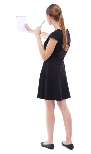 Back view of  stands woman takes notes in a notebook — Stock Photo, Image