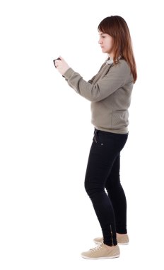 Arkadan ayakta genç kadın telefon kullanarak görünüşü