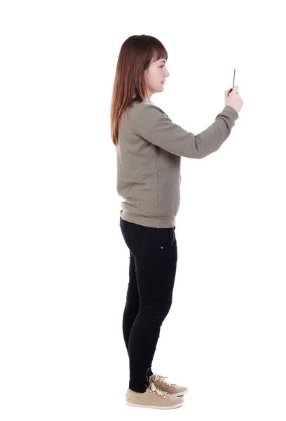Vista posterior de pie hermosa joven con un pho móvil —  Fotos de Stock