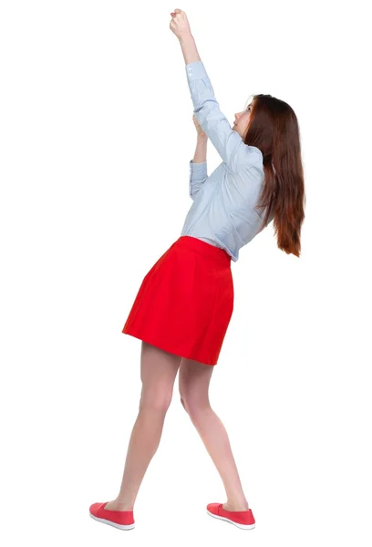 Back view of standing girl pulling a rope from the top or cling — Stock Photo, Image