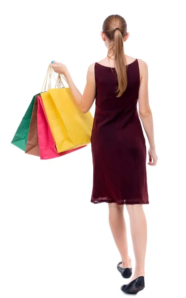 Achteraanzicht van lopende vrouw met shopping tassen . — Stockfoto
