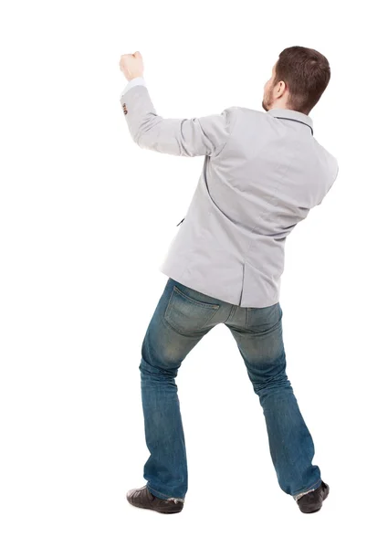 Vista posteriore di un uomo in piedi che tira una corda dall'alto o si aggrappano t — Foto Stock