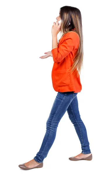 Side view of a woman walking with mobile phone. — Stock Photo, Image