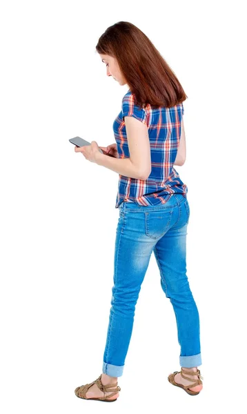 Vista posterior de pie hermosa joven con un móvil phon —  Fotos de Stock