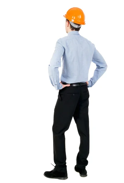 Backview of an engineer in construction helmet stands. — Stock Photo, Image