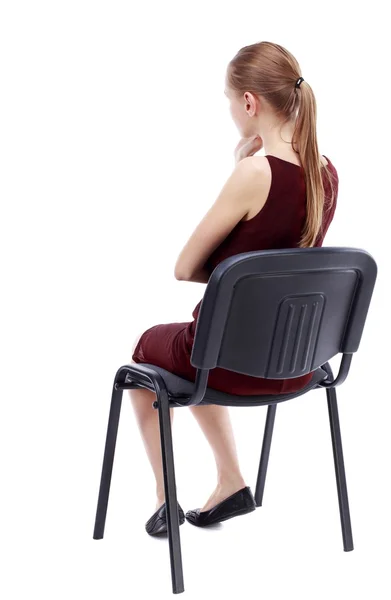 Widok z młoda piękna kobieta siedzi na krześle z tyłu. — Zdjęcie stockowe
