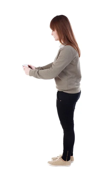Vista de pé linda jovem usando um pho móvel traseira — Fotografia de Stock