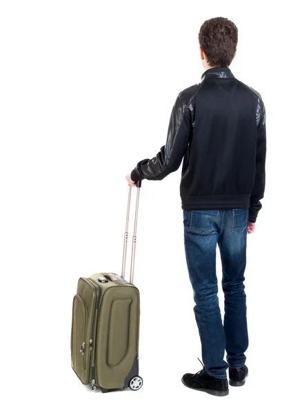 Achteraanzicht van de mens met groene koffer opzoeken. — Stockfoto