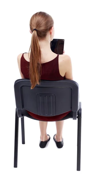 Visão da mulher sentada na cadeira de volta e olha para a tela — Fotografia de Stock