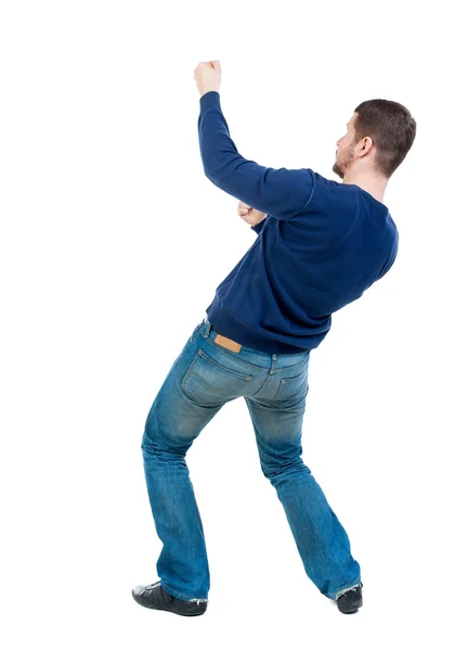 Back view of standing man pulling a rope from the top or cling t — Stock Photo, Image