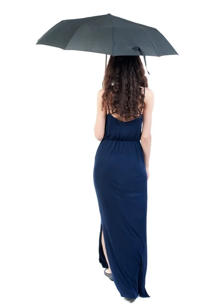 Молода жінка в сукні, що йде під парасолькою . — стокове фото