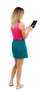 arkadan görünüşü mobil bir fon kullanan duran genç güzel kadın