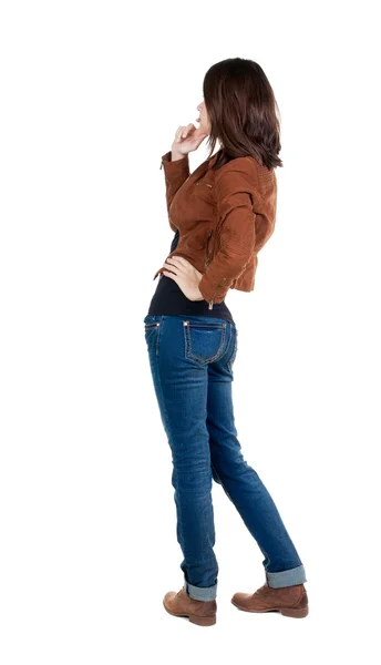 Back view of standing young beautiful  brunette woman in brown j - Stock-foto