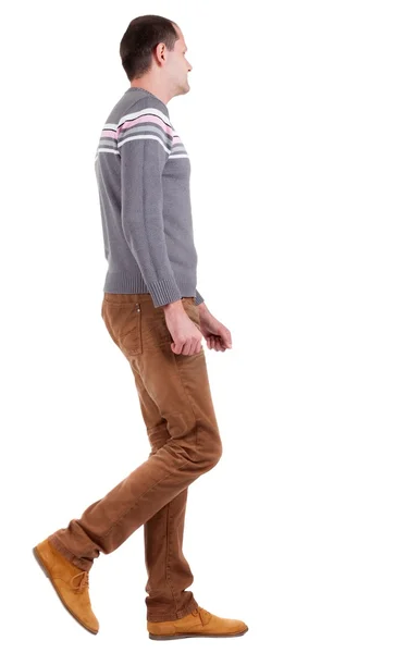Pohled zezadu na muž chodící svetr a džíny hnědé. — Stock fotografie