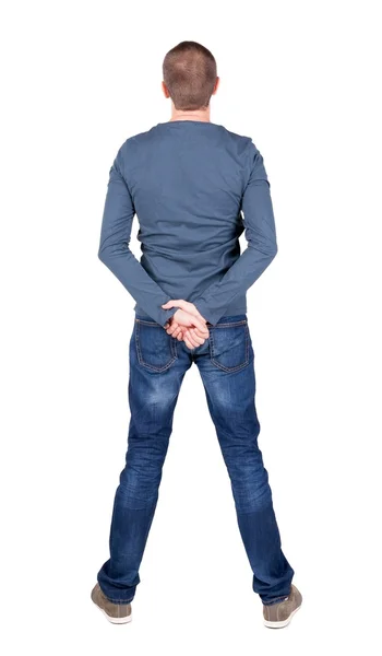 टी-शर्ट आणि जीन्स शोधत असलेल्या तरुण माणसाचे मागे दृश्य . — स्टॉक फोटो, इमेज