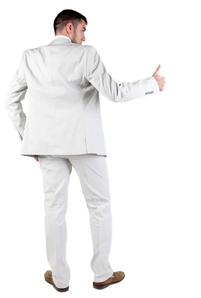 Back view of young business man in white suit going thumb up Stock Image