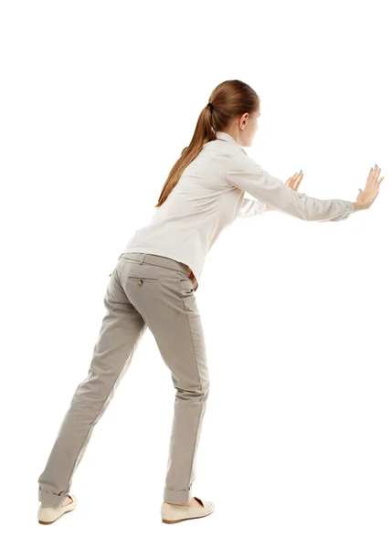 Back view of woman pushes wall. — Stock Photo, Image